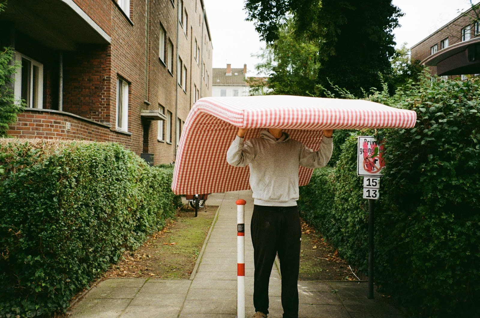 Man carrying an old mattress for removal